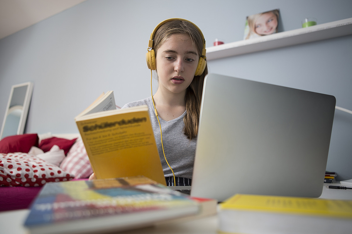 Un'adolescente impara con il portatile alla sua scrivania.