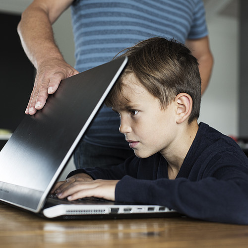 Un ragazzo è concentrato sullo schermo e non può consegnare il portatile.
