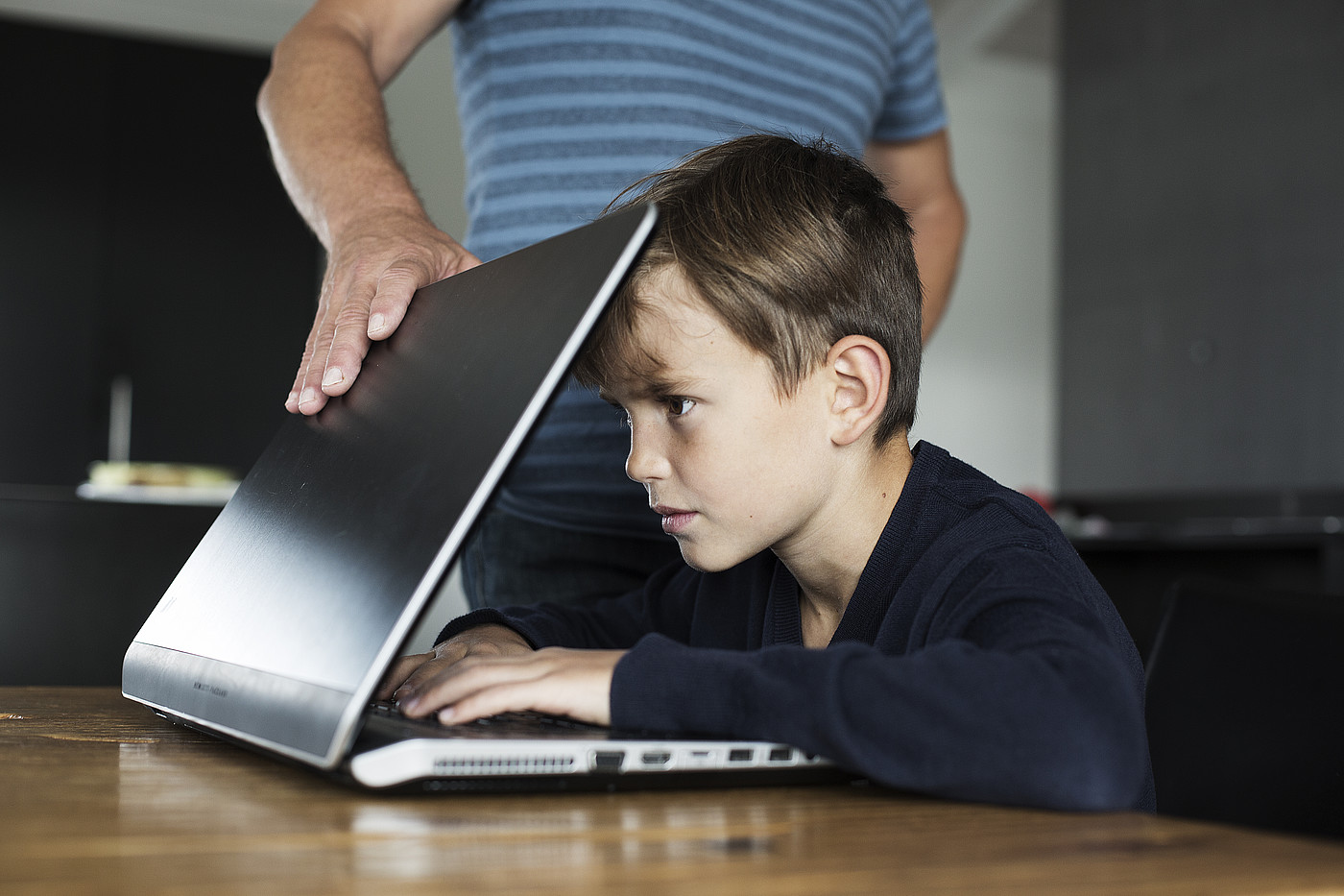 Un ragazzo è concentrato sullo schermo e non può consegnare il portatile.