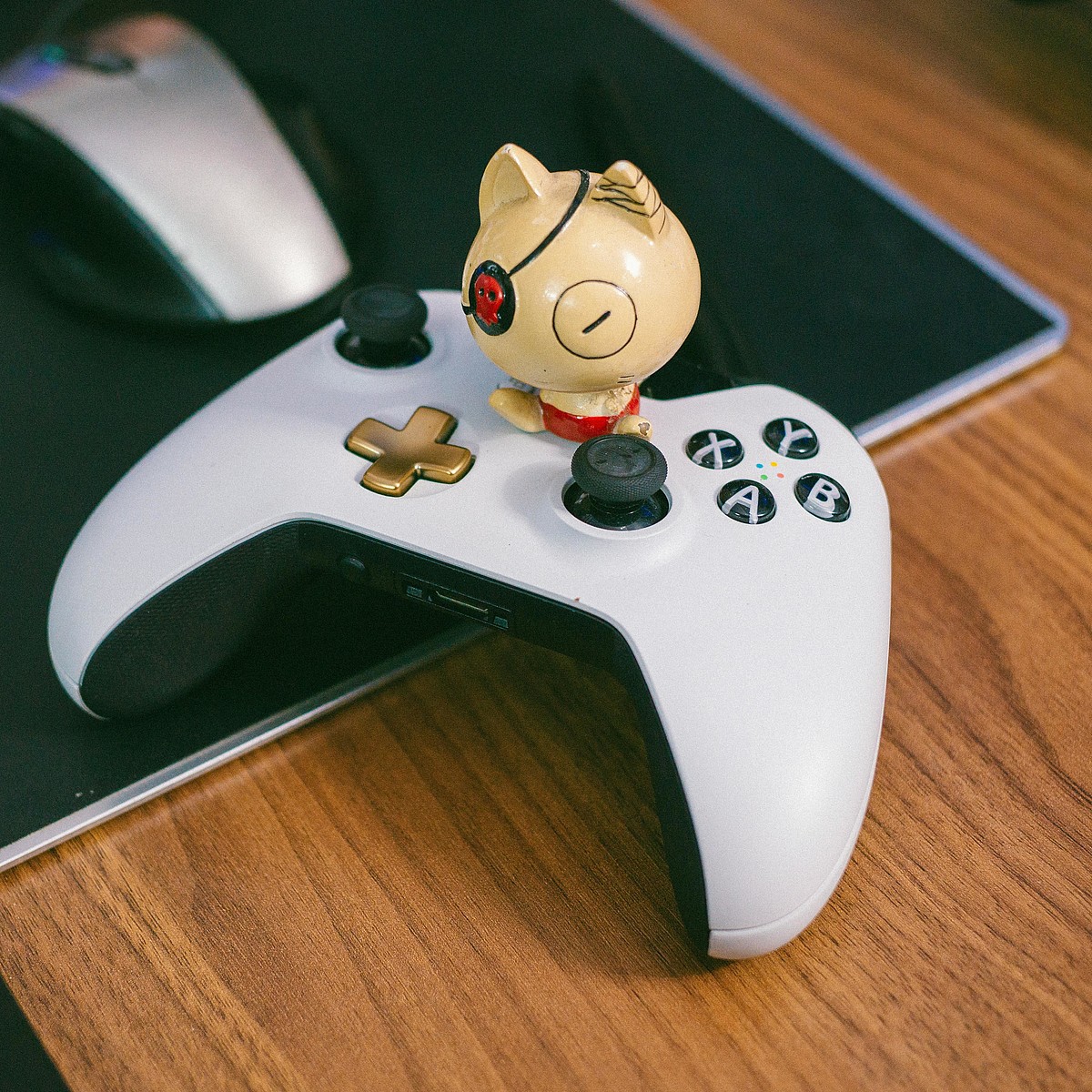 Controller da gioco bianco e nero su una scrivania con un personaggio dei fumetti