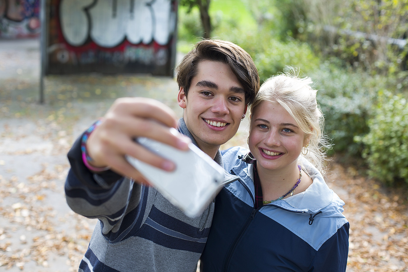 Un ragazzo e una ragazza scattano una foto insieme con il cellulare. 