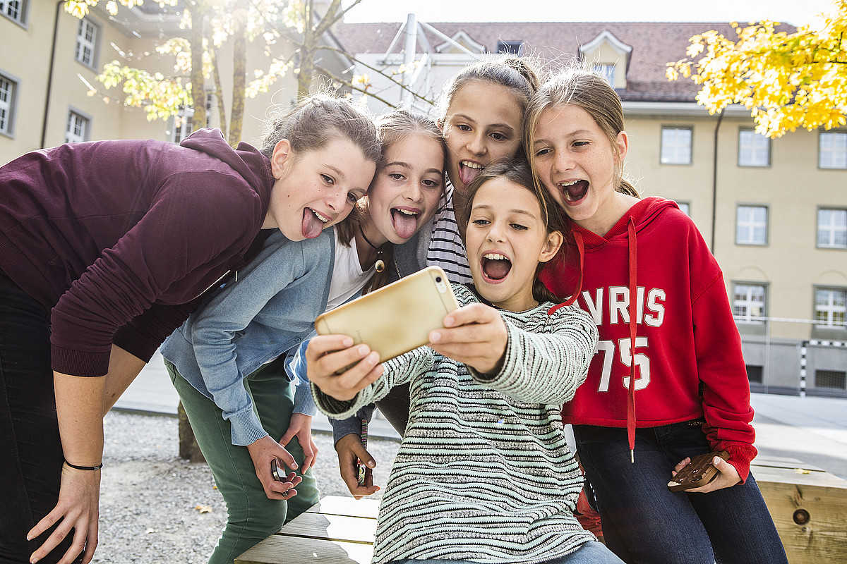 Cinque ragazze adolescenti che si fanno un selfie.