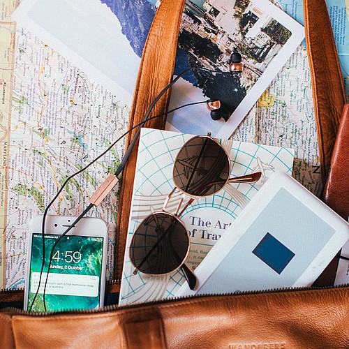 [Translate to Italienisch:] Tasche mit Reisesachen und Smartphone