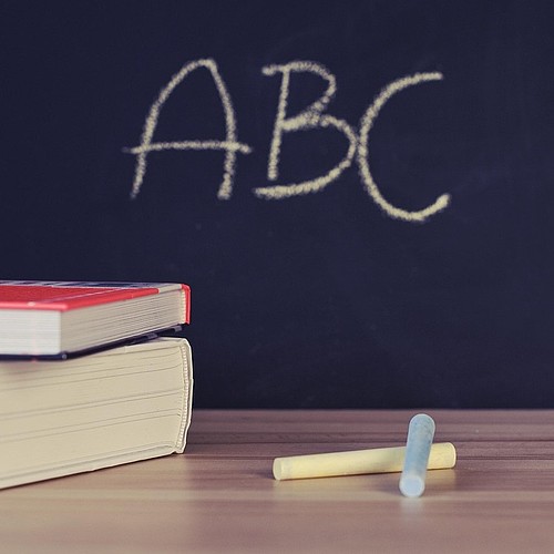 Lavagna con le lettere A, B e C, libri e gesso