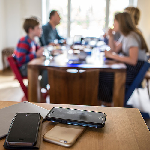 Gli smartphone sono lontani dal tavolo da pranzo mentre la famiglia sta mangiando.
