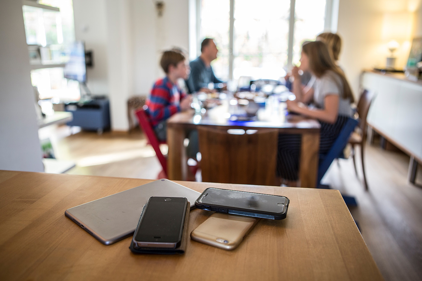 Gli smartphone sono lontani dal tavolo da pranzo mentre la famiglia sta mangiando.