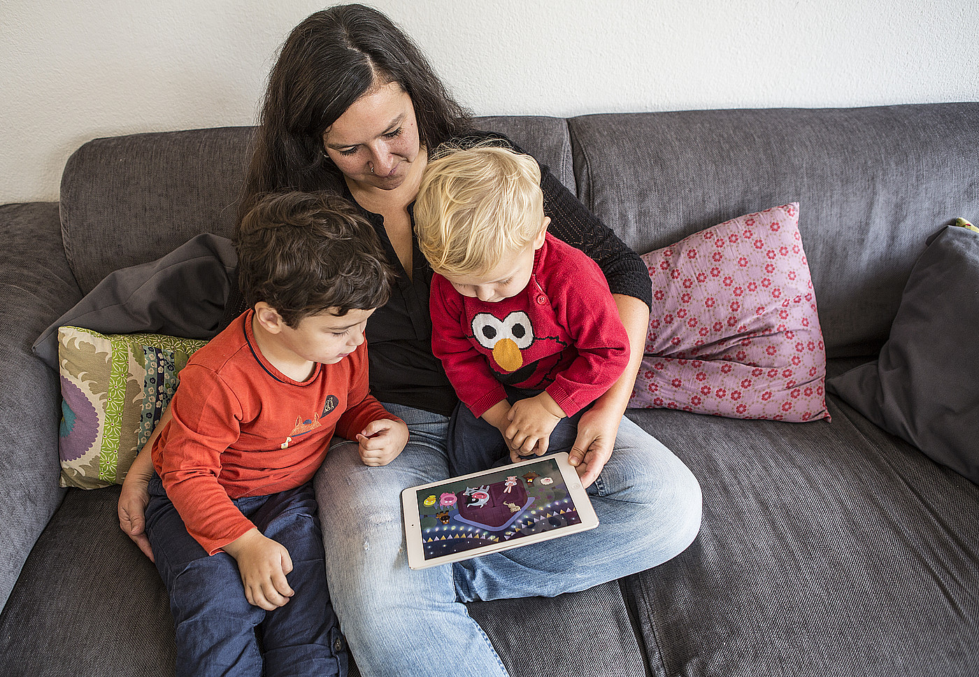 Una donna che mostra un film ai bambini su un tablet.