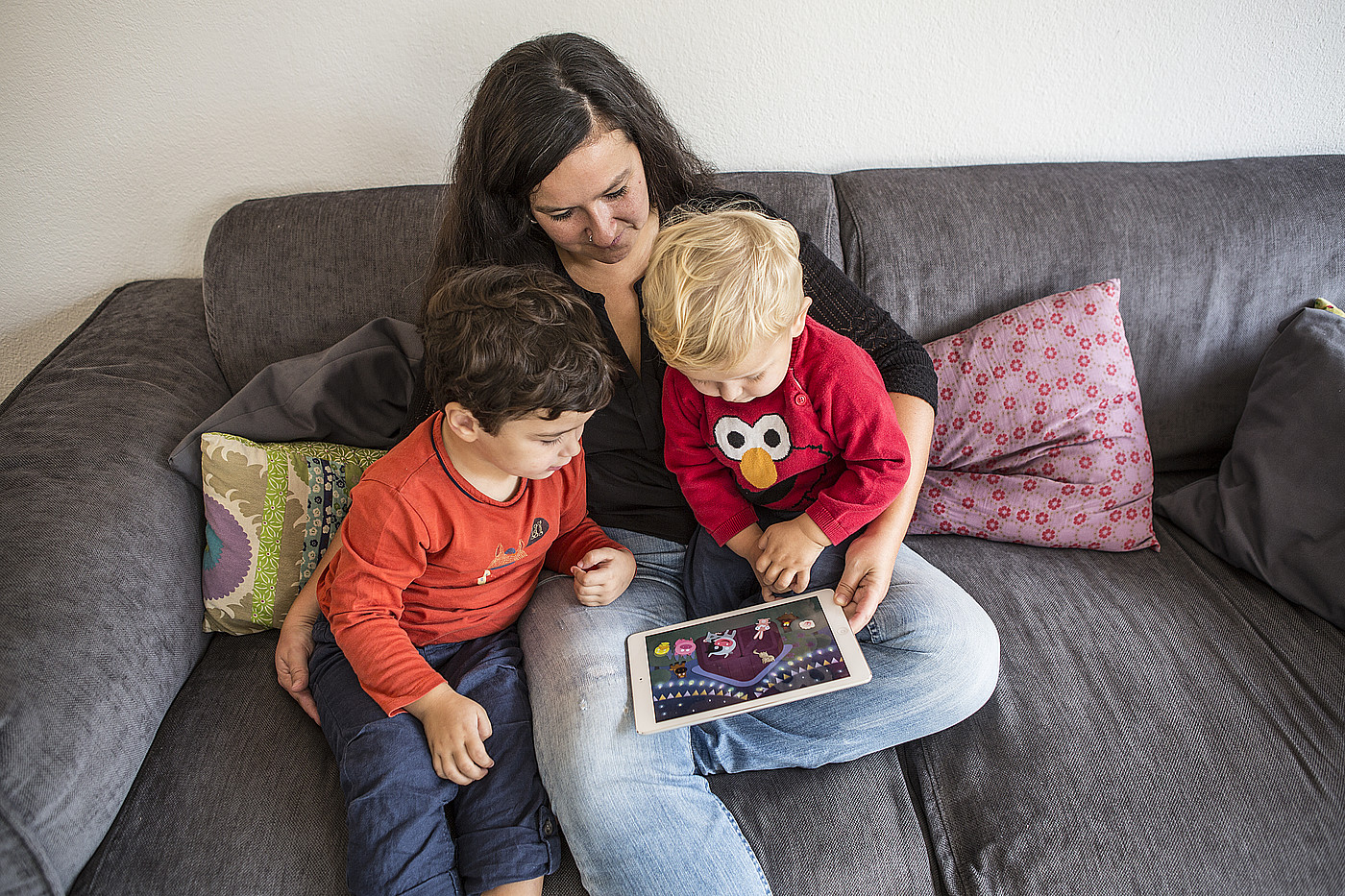 Una donna che mostra un film ai bambini su un tablet.