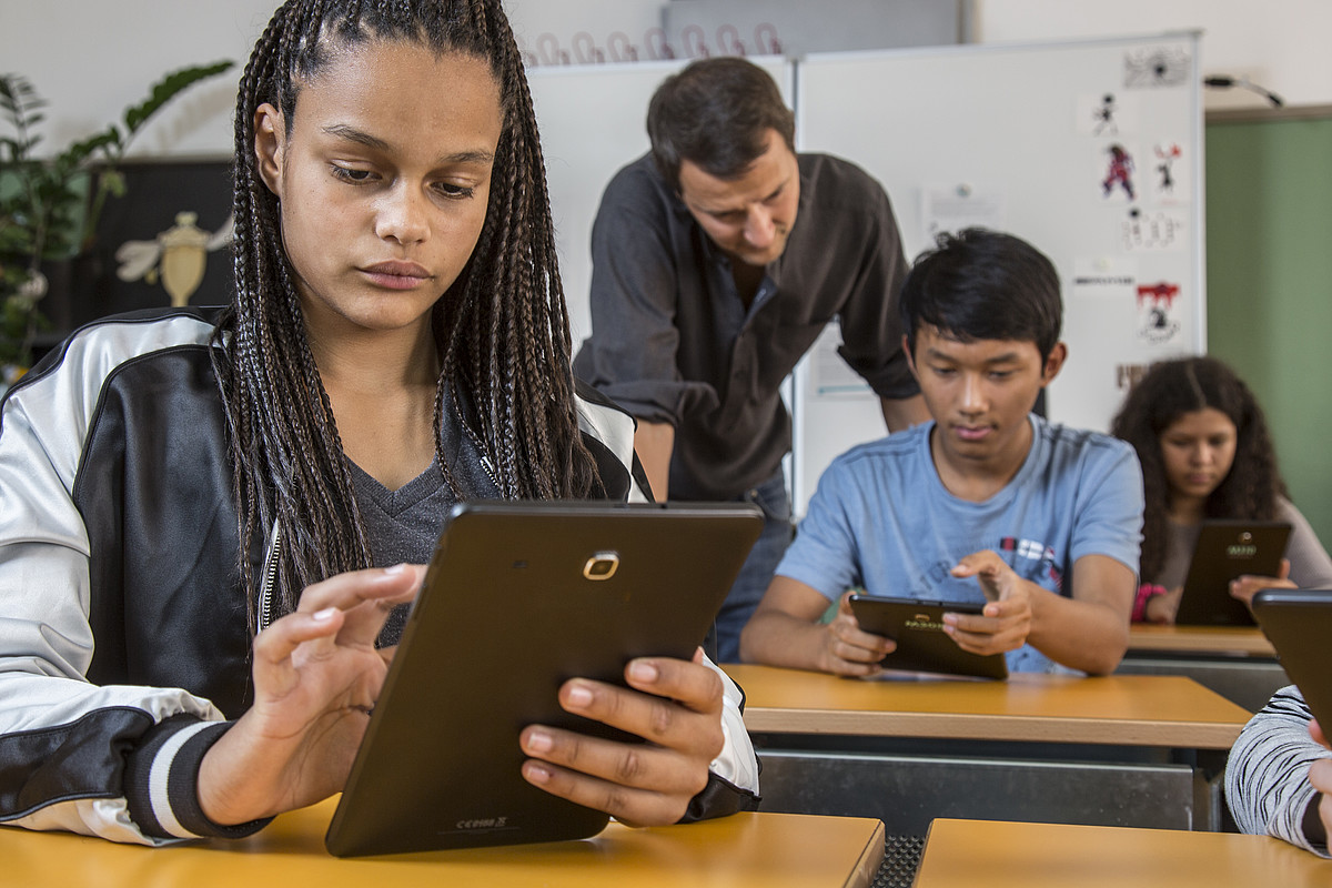 Gli alunni usano i cellulari in classe.